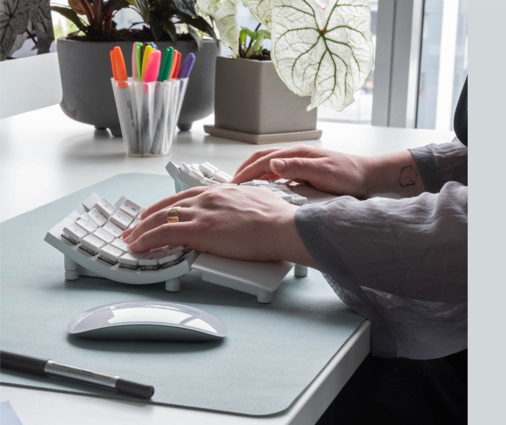 Person in office typing on Glove80 ergonomic keyboard using built-in wrist rests