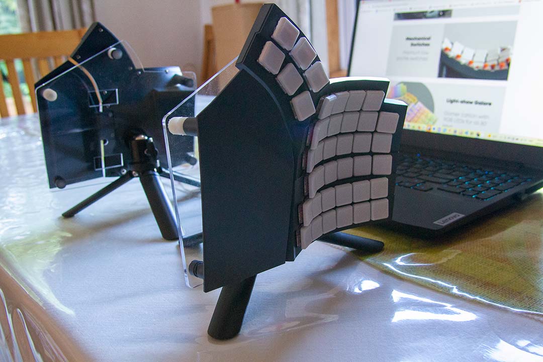 Glove80 keyboard mounted onto vertical tripod for ergonomic desktop use